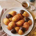 Recette madeleine moelleuse Cyril Lignac, madeleines dorées à bosse sur assiette blanche