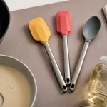 Ustensiles de cuisine en silicone sur plan de travail : spatule et cuillère pour protéger l’antiadhésif