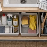 Rangement produits ménagers : accessoires triés sous évier, bacs et nettoyants rangés